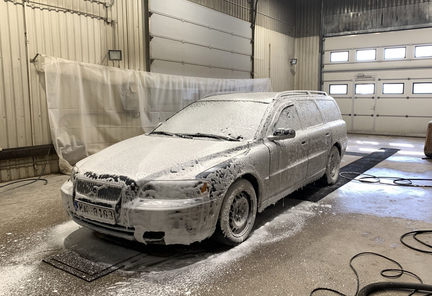 Balts auto garāžā klāts ar putām.