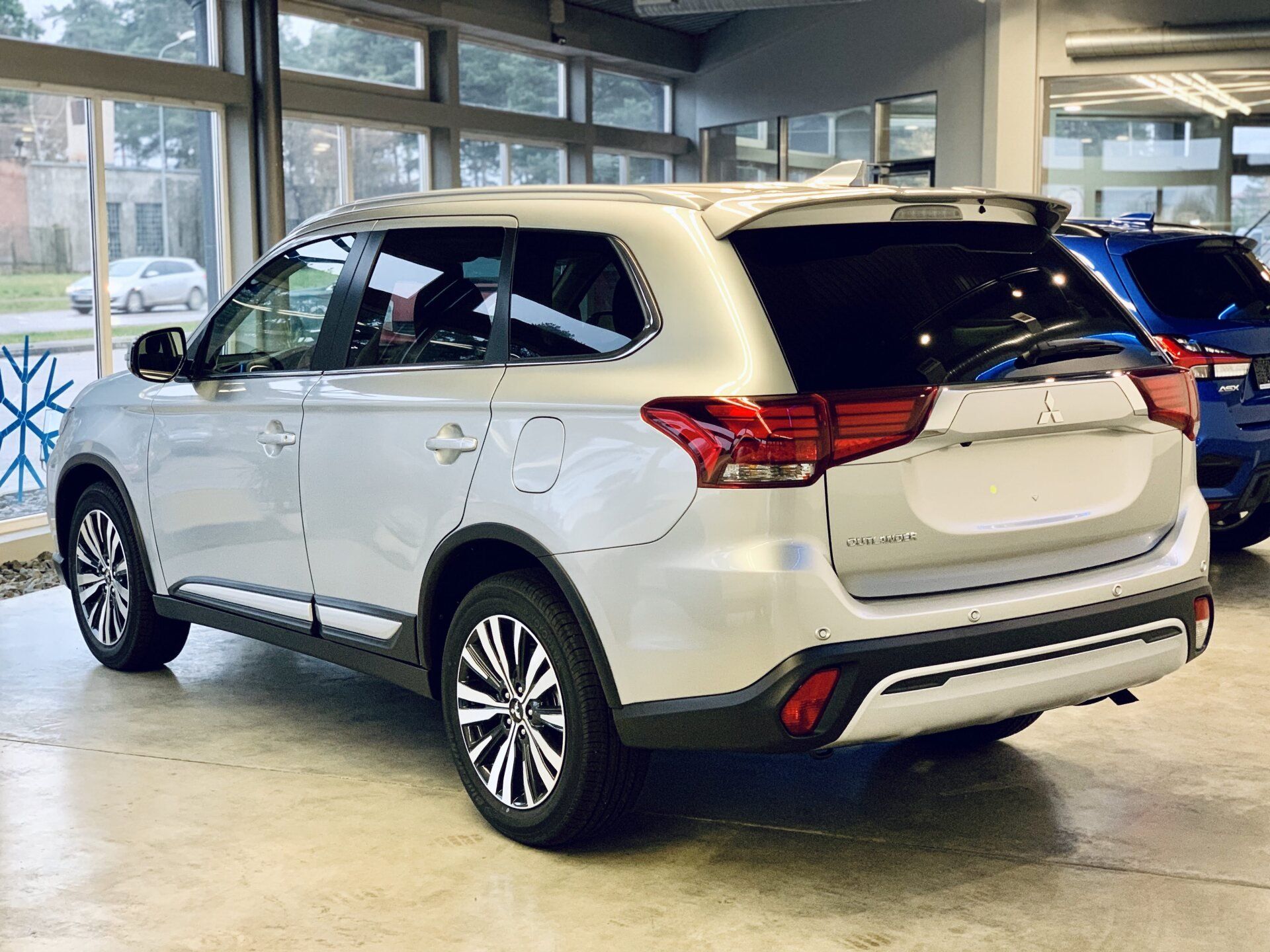 Izstāžu zālē stāv balts apvidus auto.