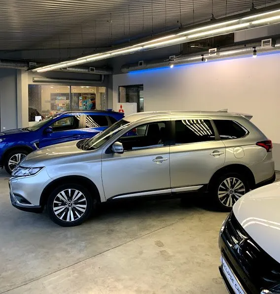 Automašīnu rinda ir novietota izstāžu zālē.