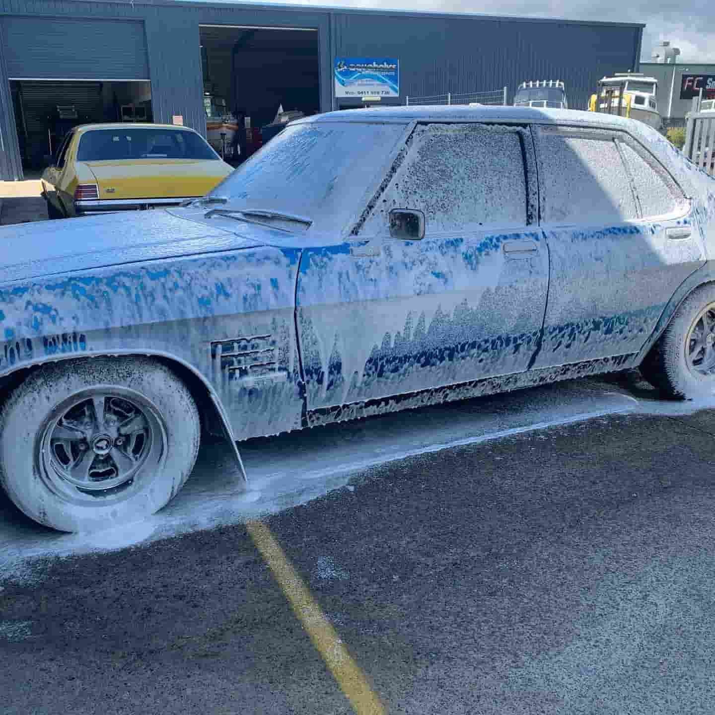 A Dirty Car Is Covered In Foam In A Parking Lot — Fraser Coast Automotive Coatings in Dundowran, QLD