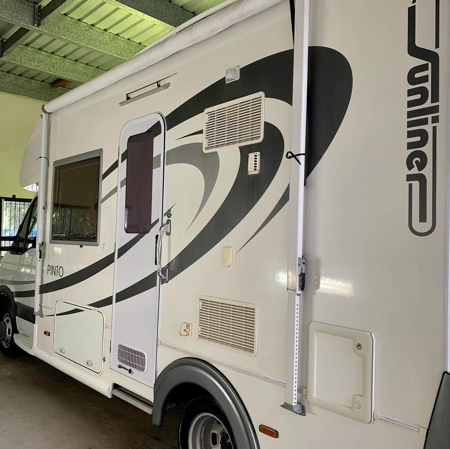 A White And Black Rv Is Parked In A Garage — Fraser Coast Automotive Coatings in Dundowran, QLD
