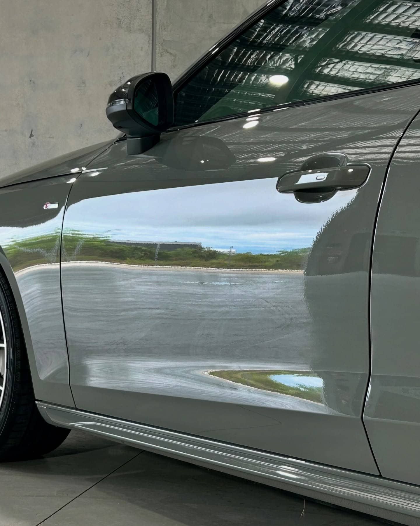A Gray Car Is Parked In A Garage With The Door Open — Fraser Coast Automotive Coatings in Dundowran, QLD