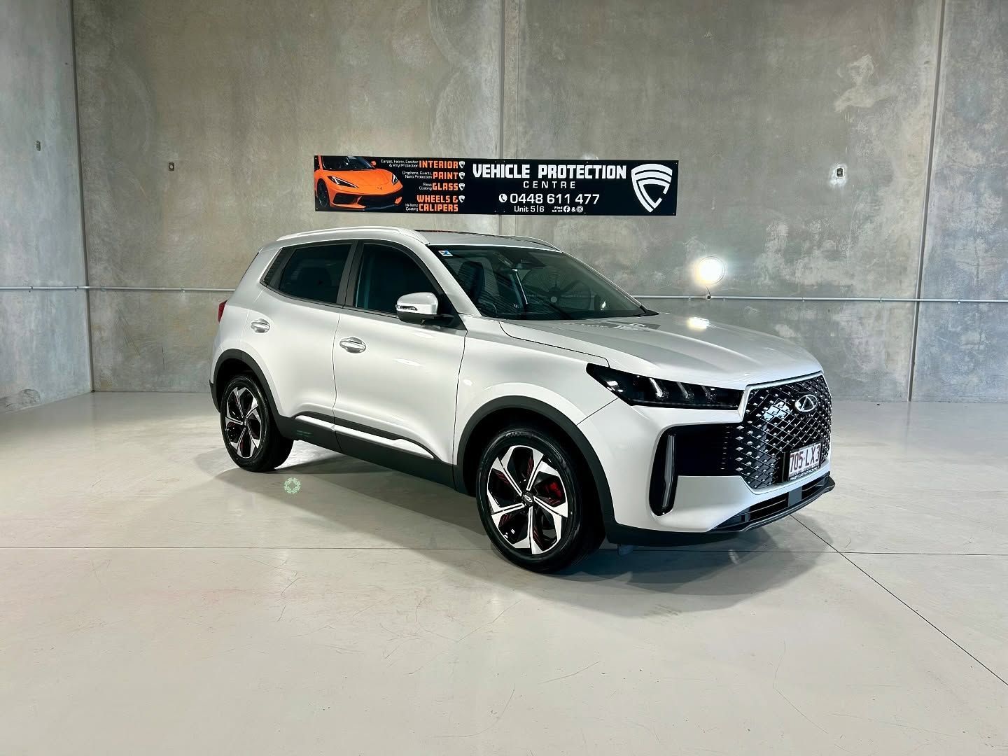 A White Suv Is Parked In A Garage Next To A Concrete Wall — Fraser Coast Automotive Coatings in Dundowran, QLD