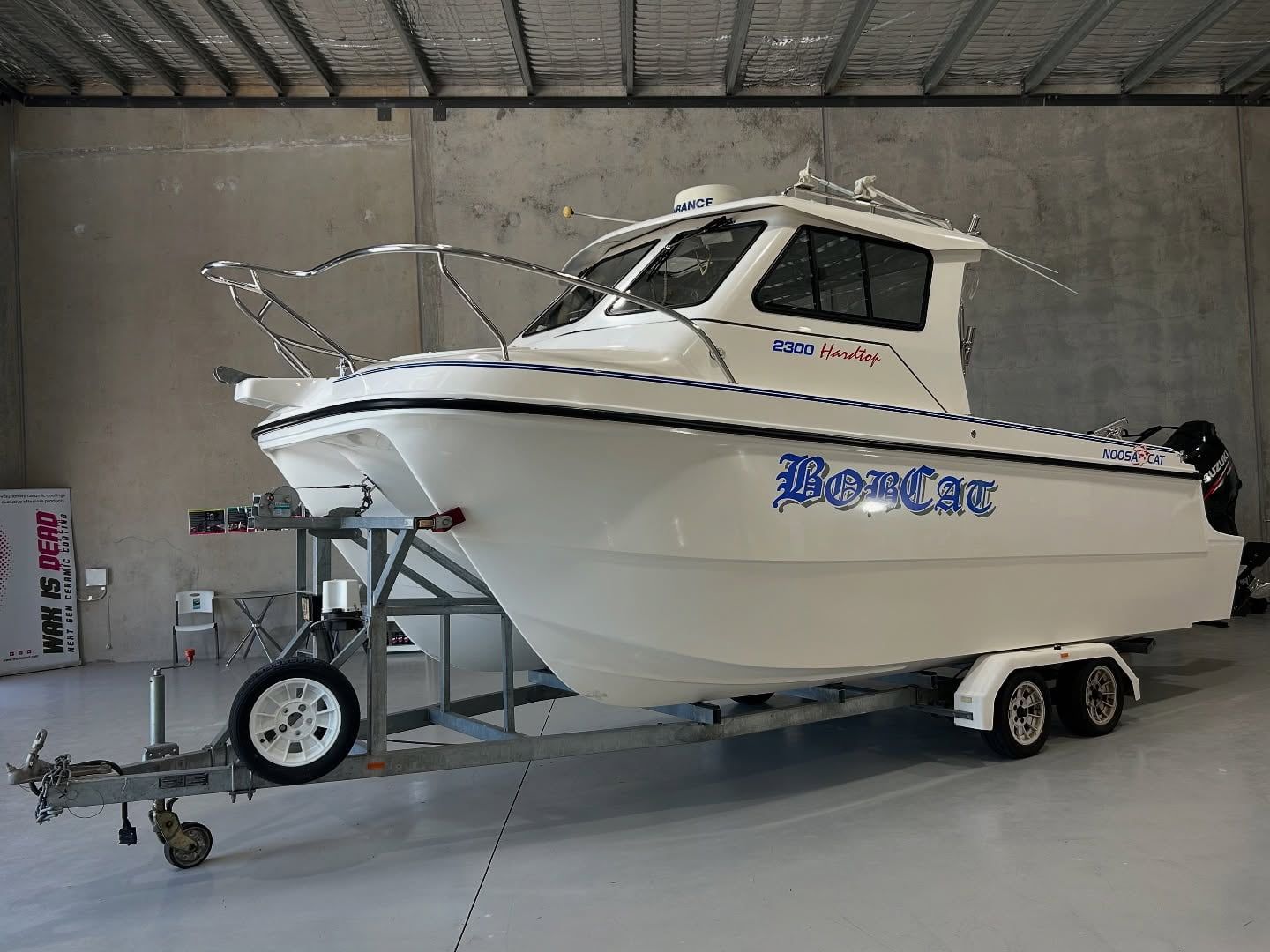A White Boat Is On A Trailer In A Warehouse — Fraser Coast Automotive Coatings in Dundowran, QLD