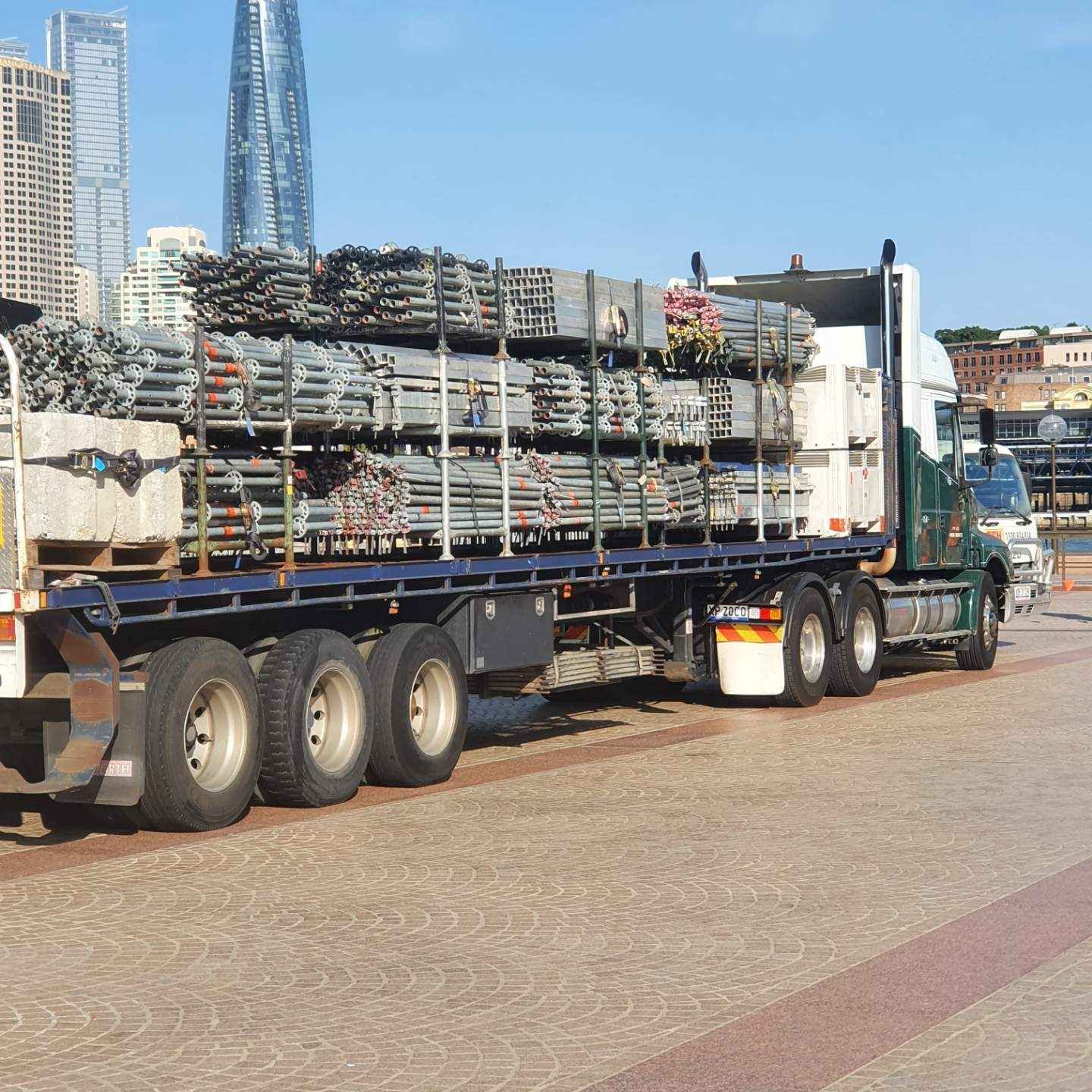 A semi truck is loaded with blue chairs in a warehouse.