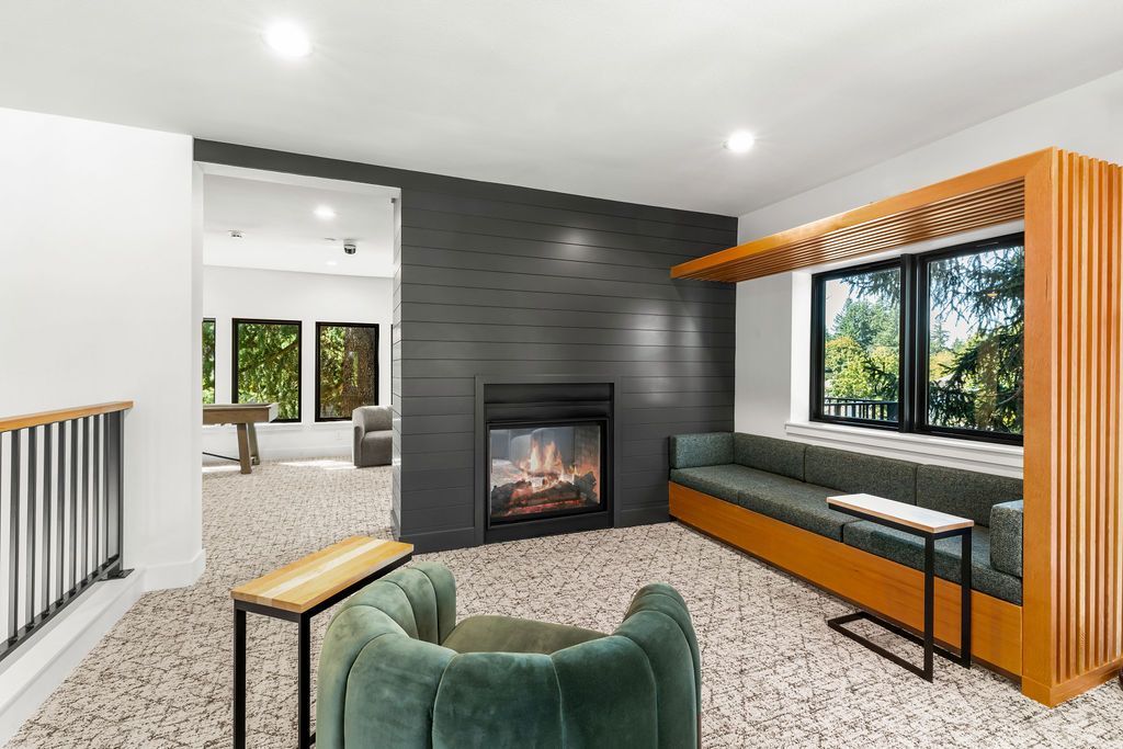 Cozy modern lounge area with fireplace, green seating, and wooden accents.