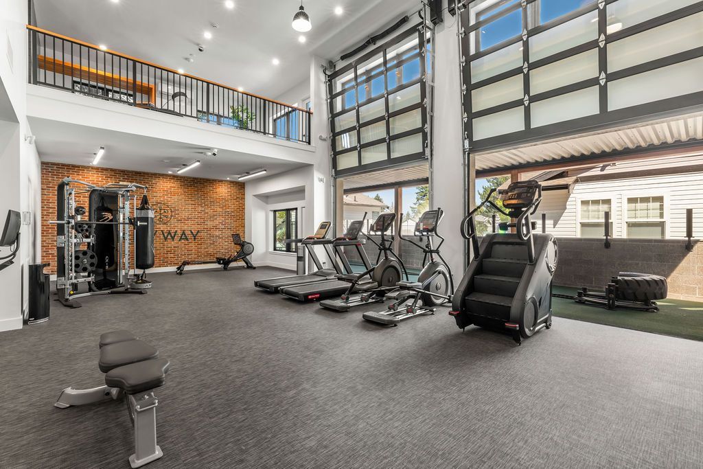 Gym with exercise equipment, including treadmills and a stair climber. A loft is above.