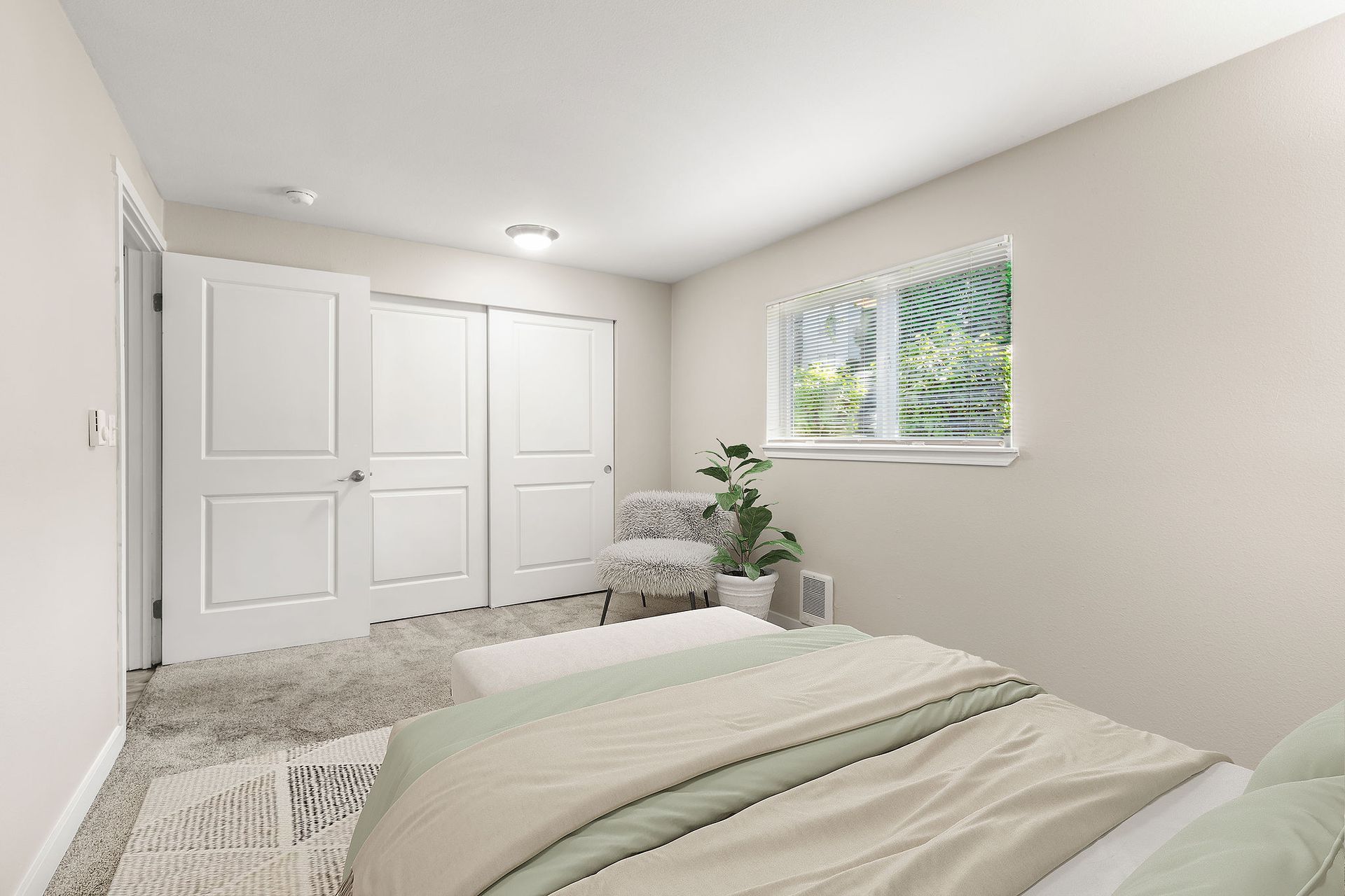 Bedroom with bed, closet, window with blinds, and a small chair.