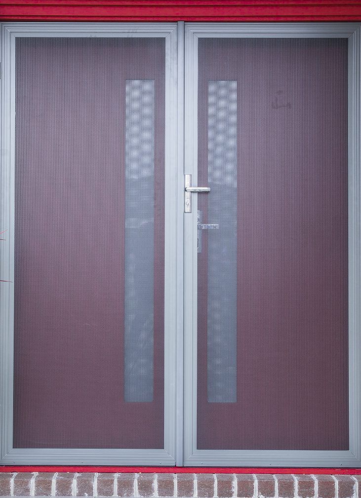A Close Up Of A Screen Door On A Red Brick Wall — Eastcoast Aluminium & Glass In Ballina, NSW