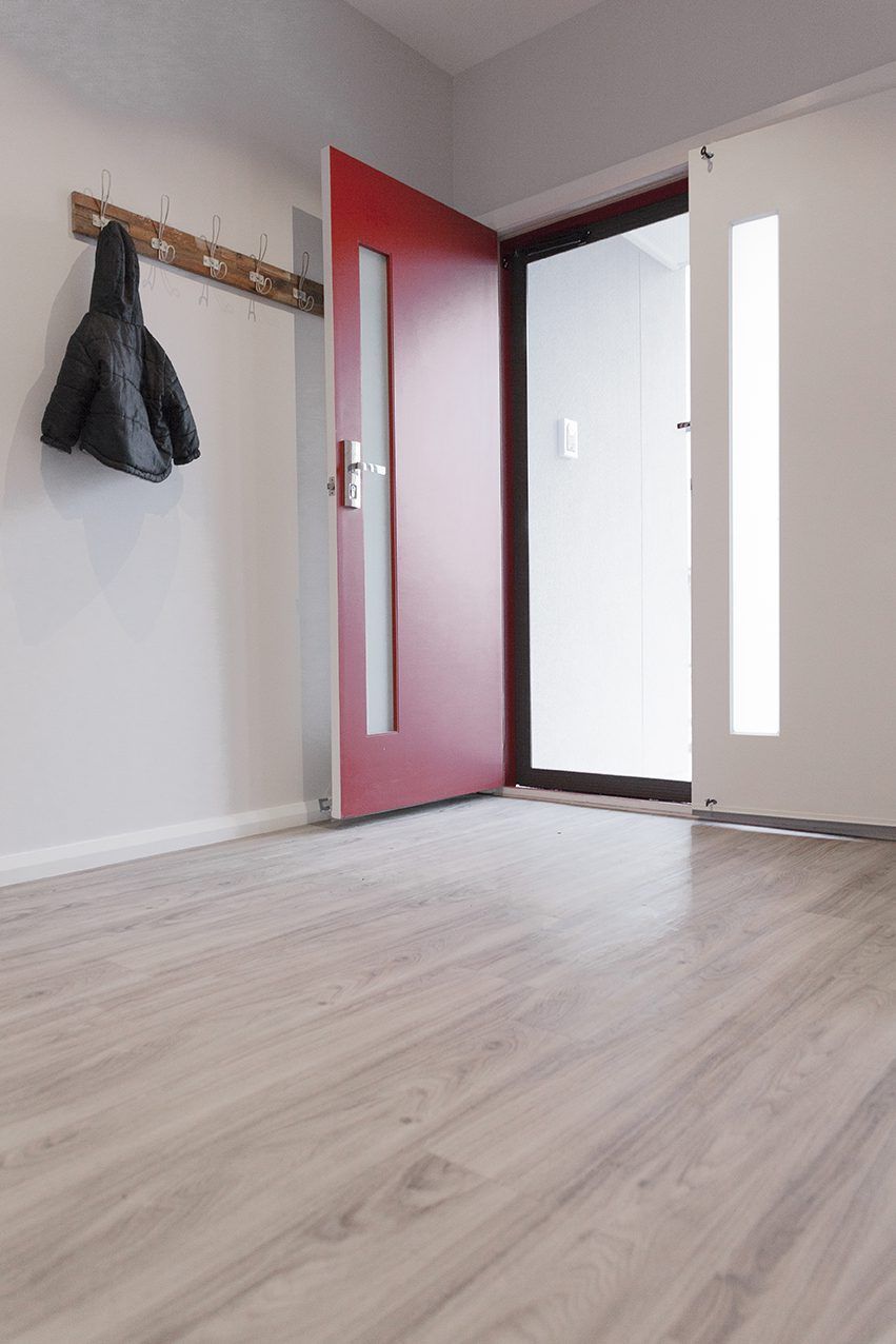 An Empty Hallway With A Red Door And A Coat Hanging On A Hook — Eastcoast Aluminium & Glass In Ballina, NSW