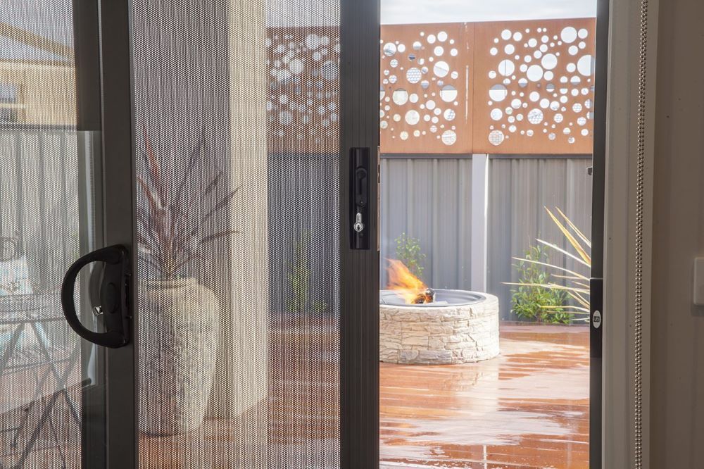 Sliding security screen door with fine mesh, offering outdoor visibility and secure home protection.