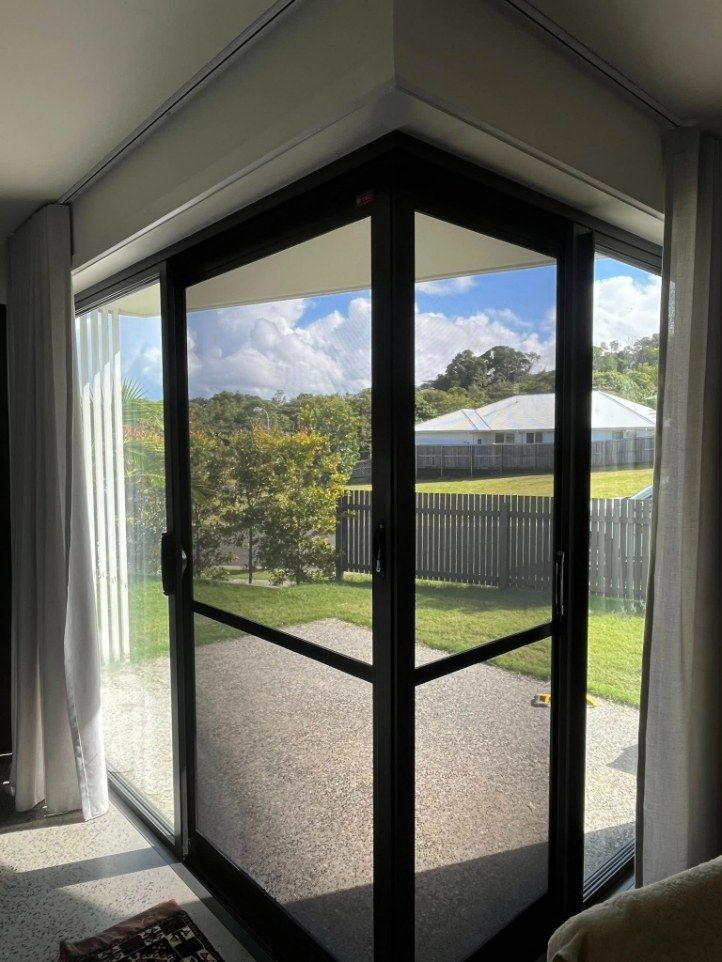A Black-framed Glass Sliding Door With a View of a Yard — Eastcoast Aluminium & Glass In Ballina, NSW