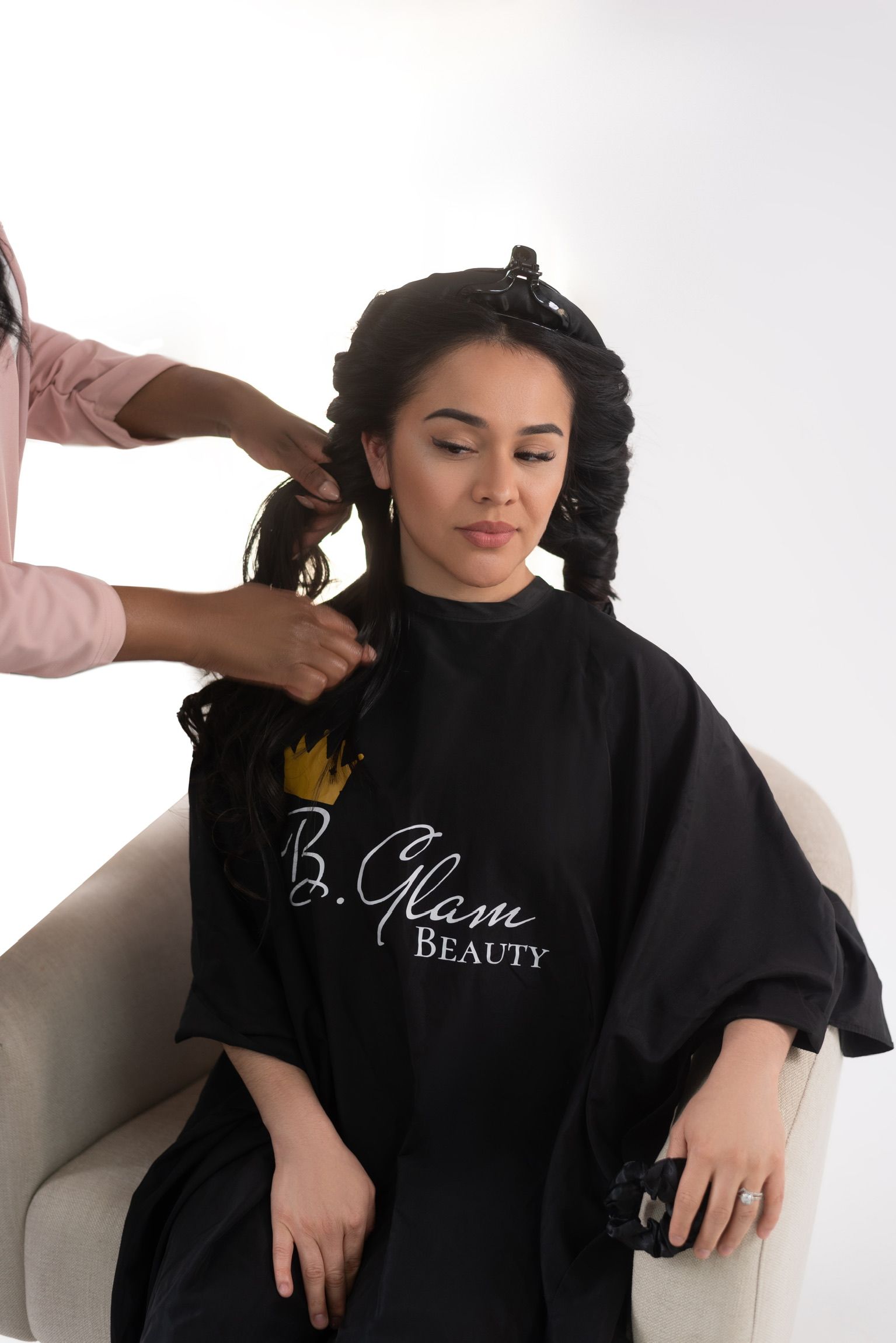 a lady wearing a salon cape getting her hair styled