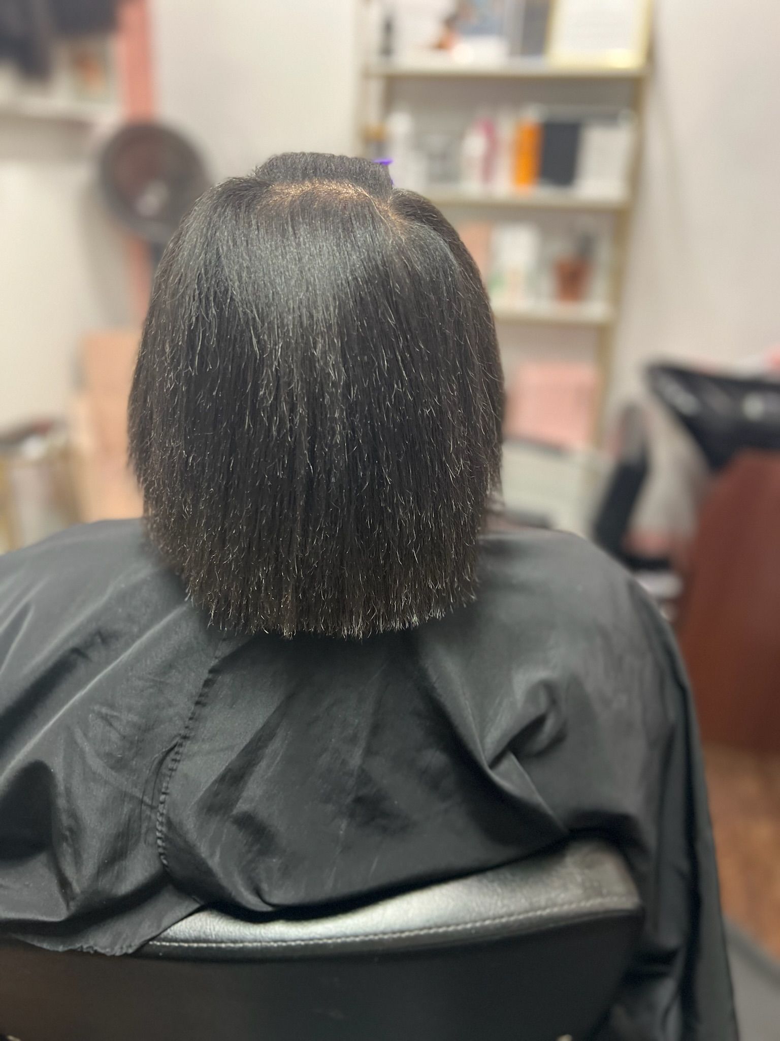 a black haired lady in a salon chair