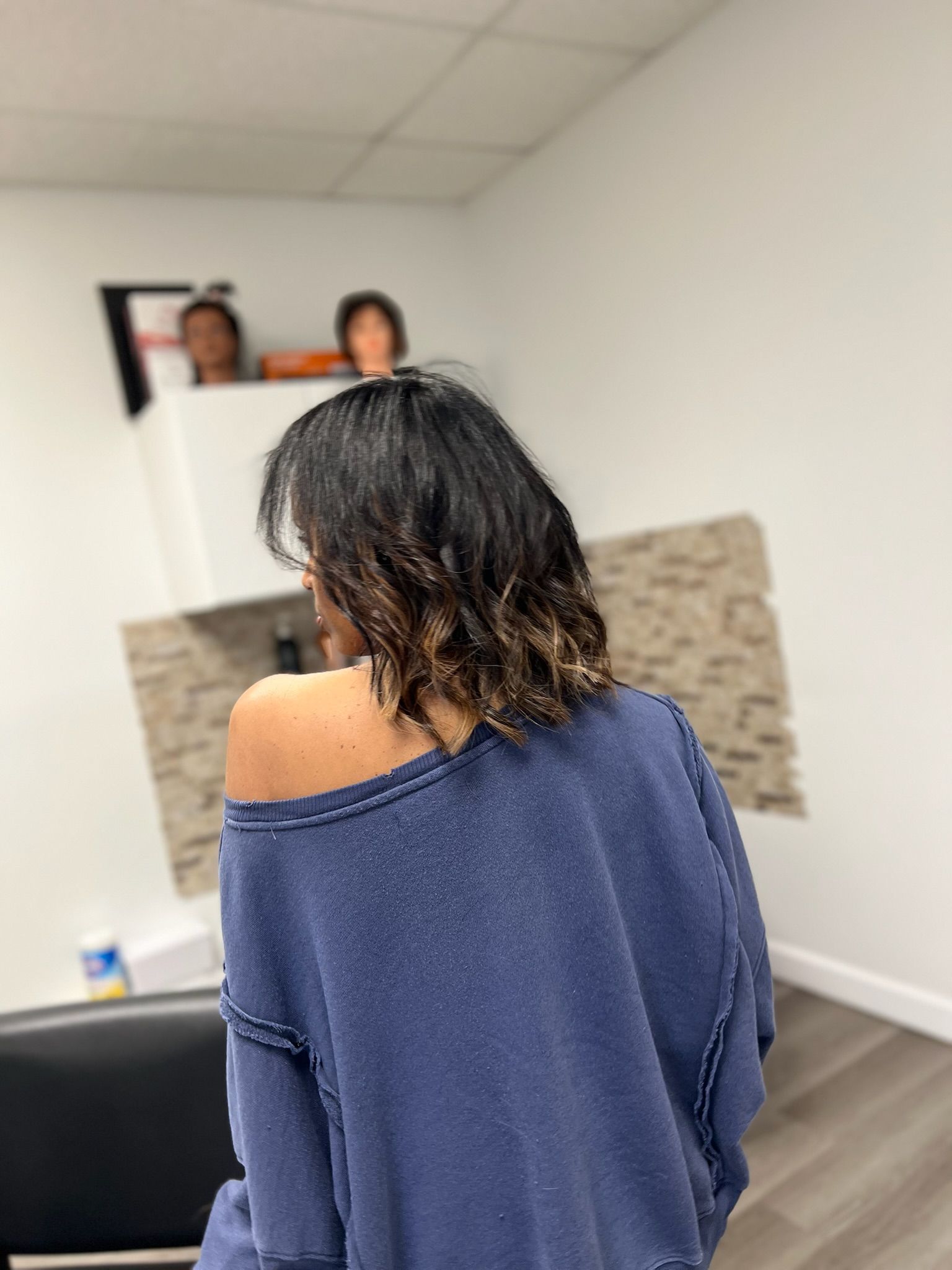 a lady in a salon with short dark hair with blond tips