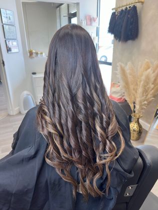 a lady with long hair that is freshly styled in curls