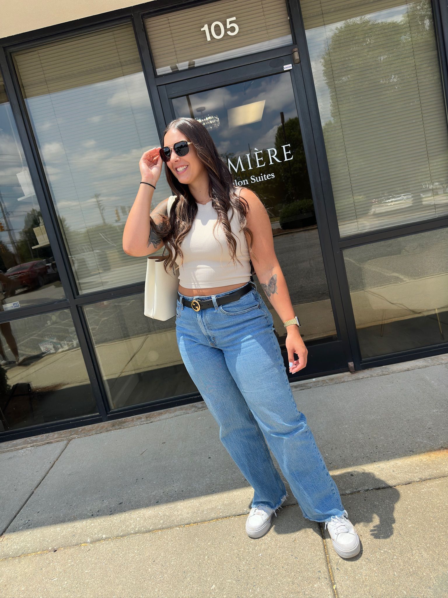 a beautiful lady outside of a hair salon posing with her new haircut