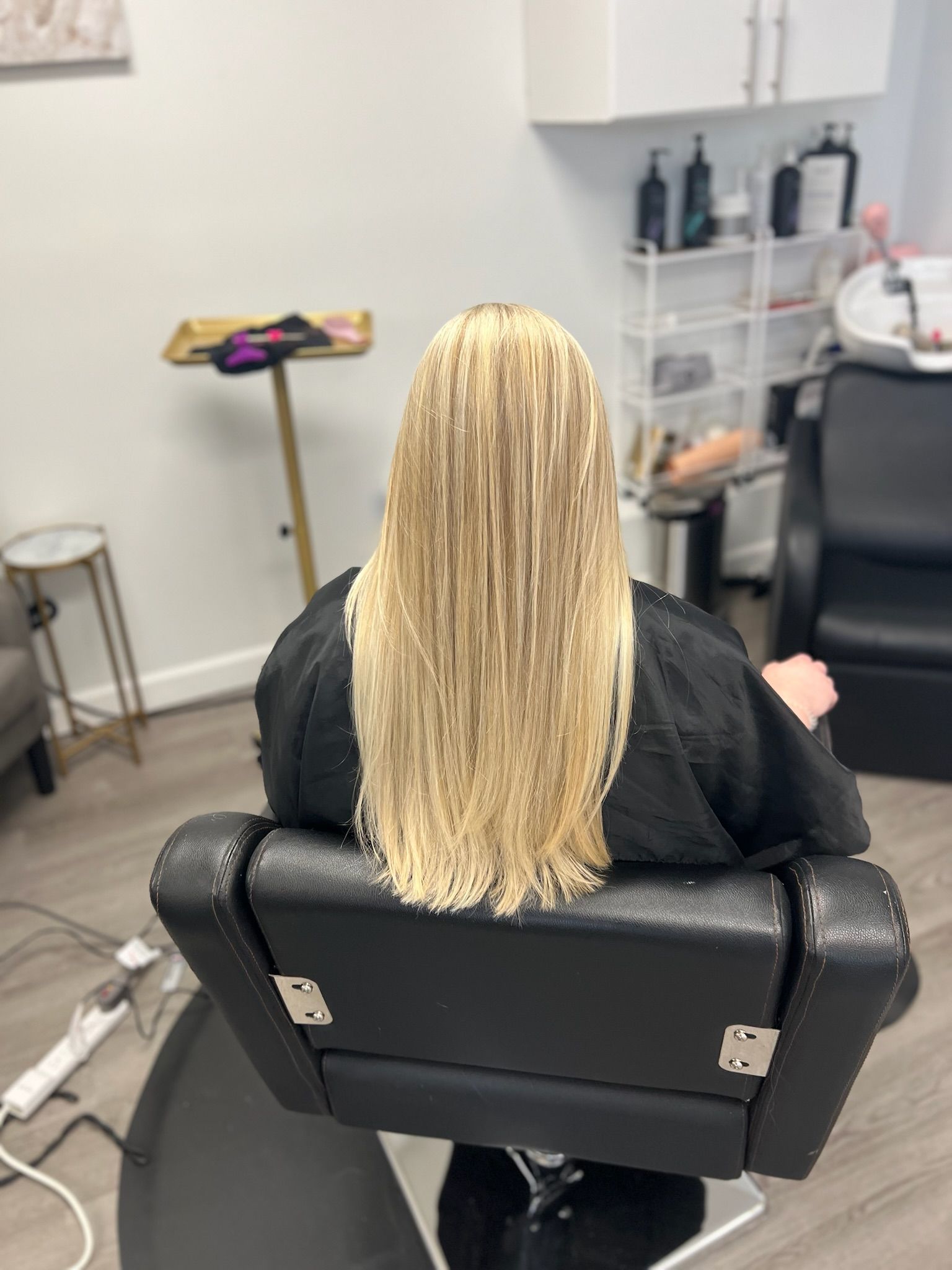 a lady showing her long blond hair in a hair salon