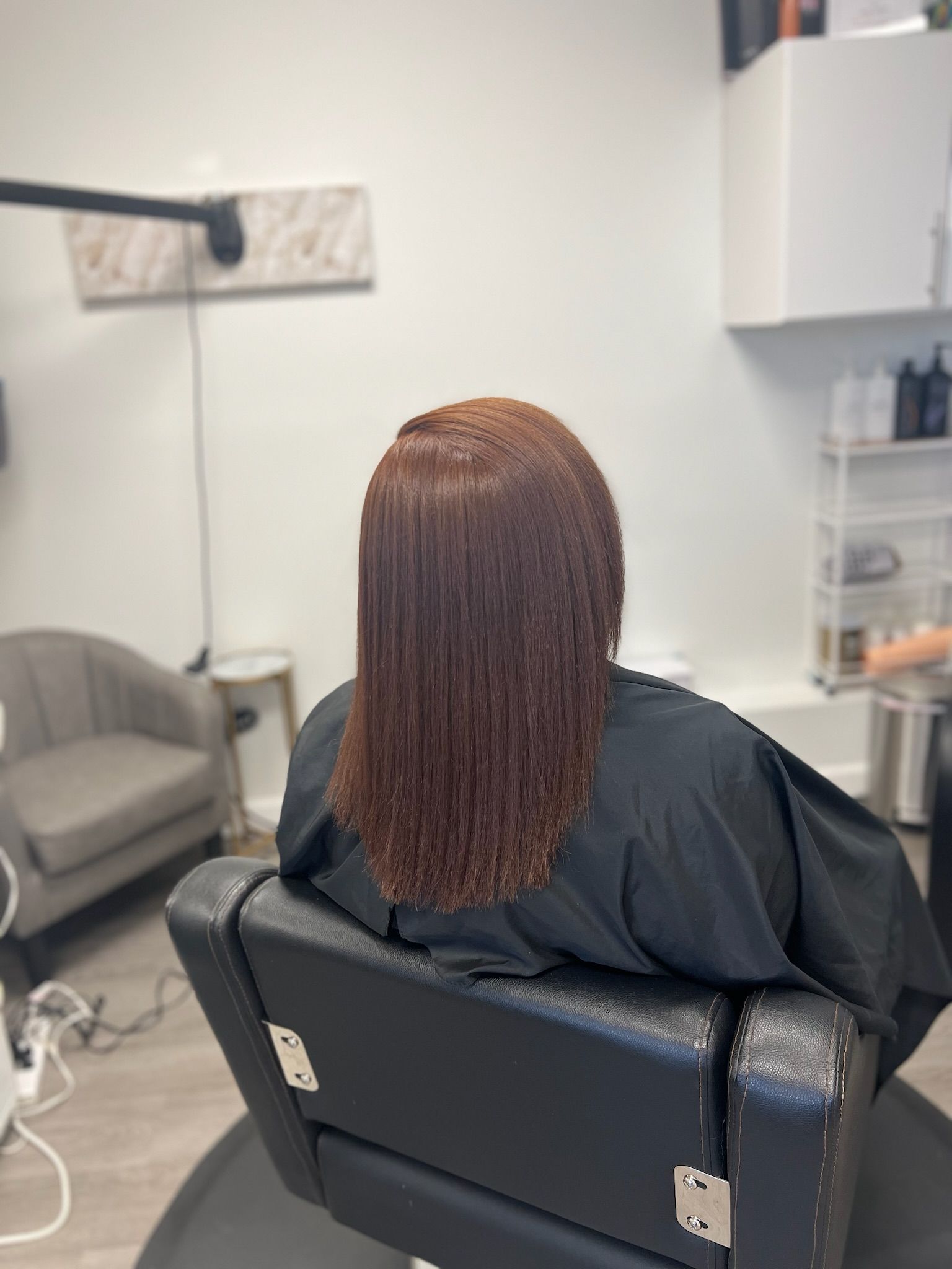 a lady showing her freshly fully colored hair- a red brown color