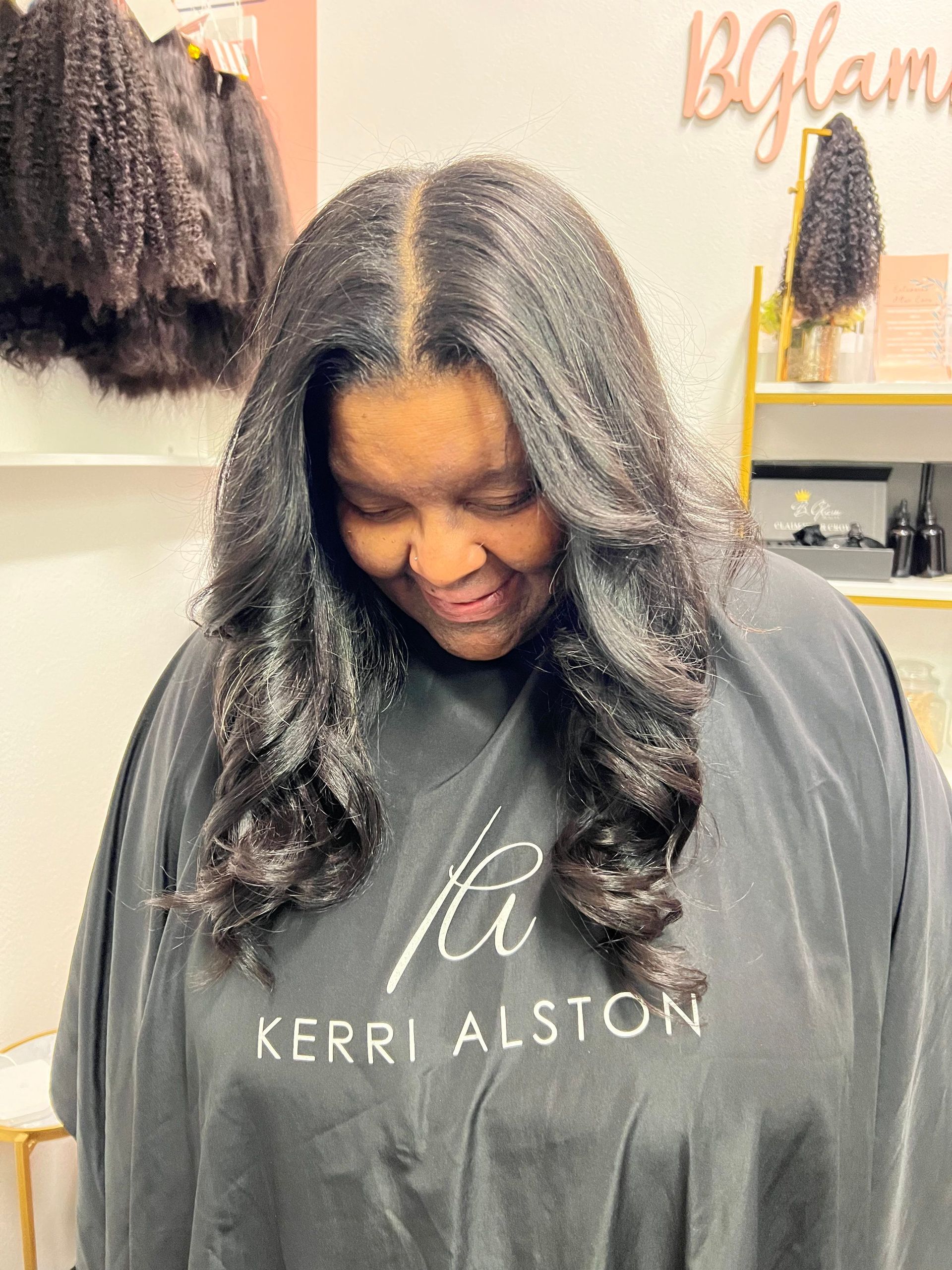 a lady in a salon with dar haiir hanging styled around her face