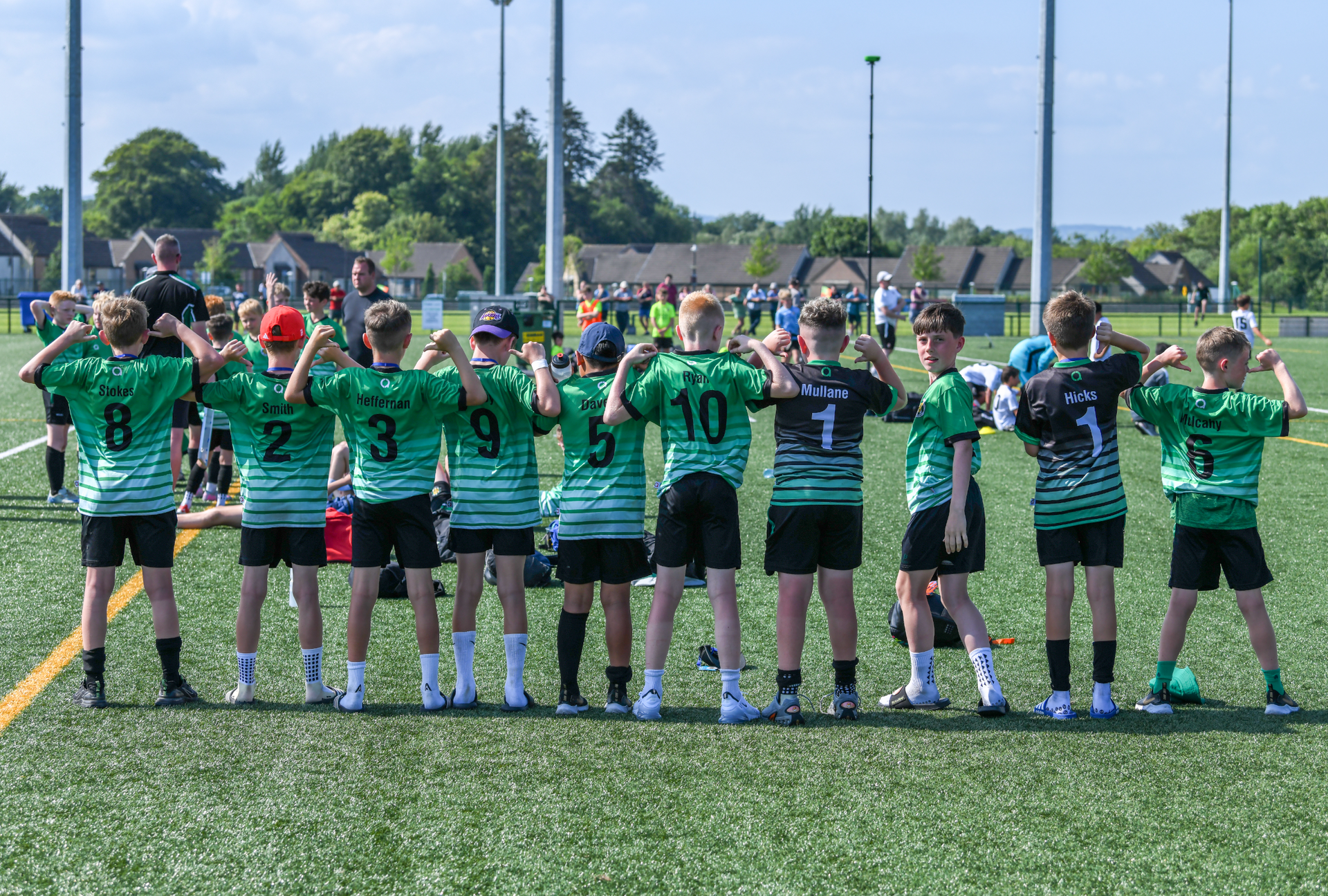 A group of young boys are standing in a row on a soccer field.