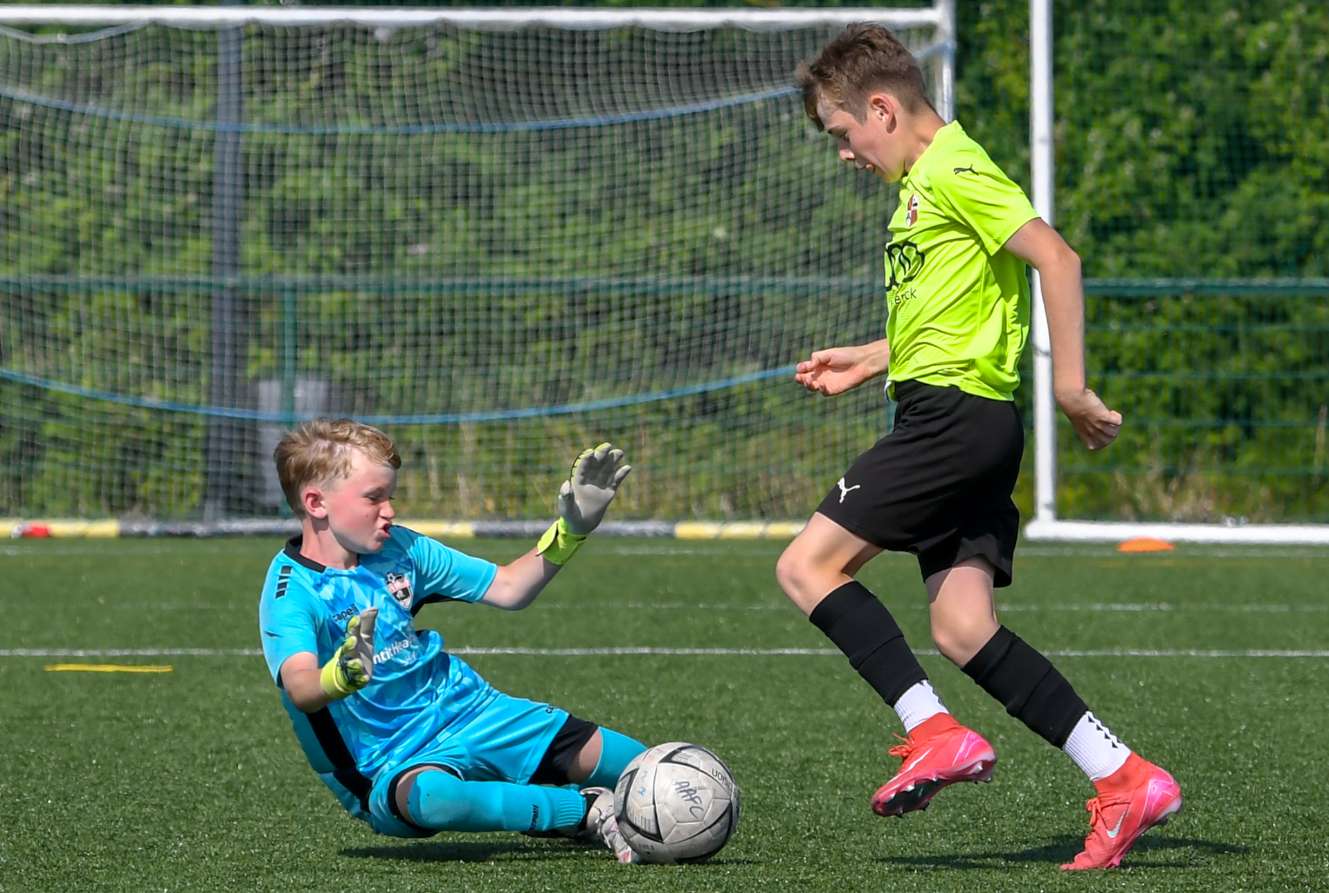 Two young boys are playing soccer on a field.