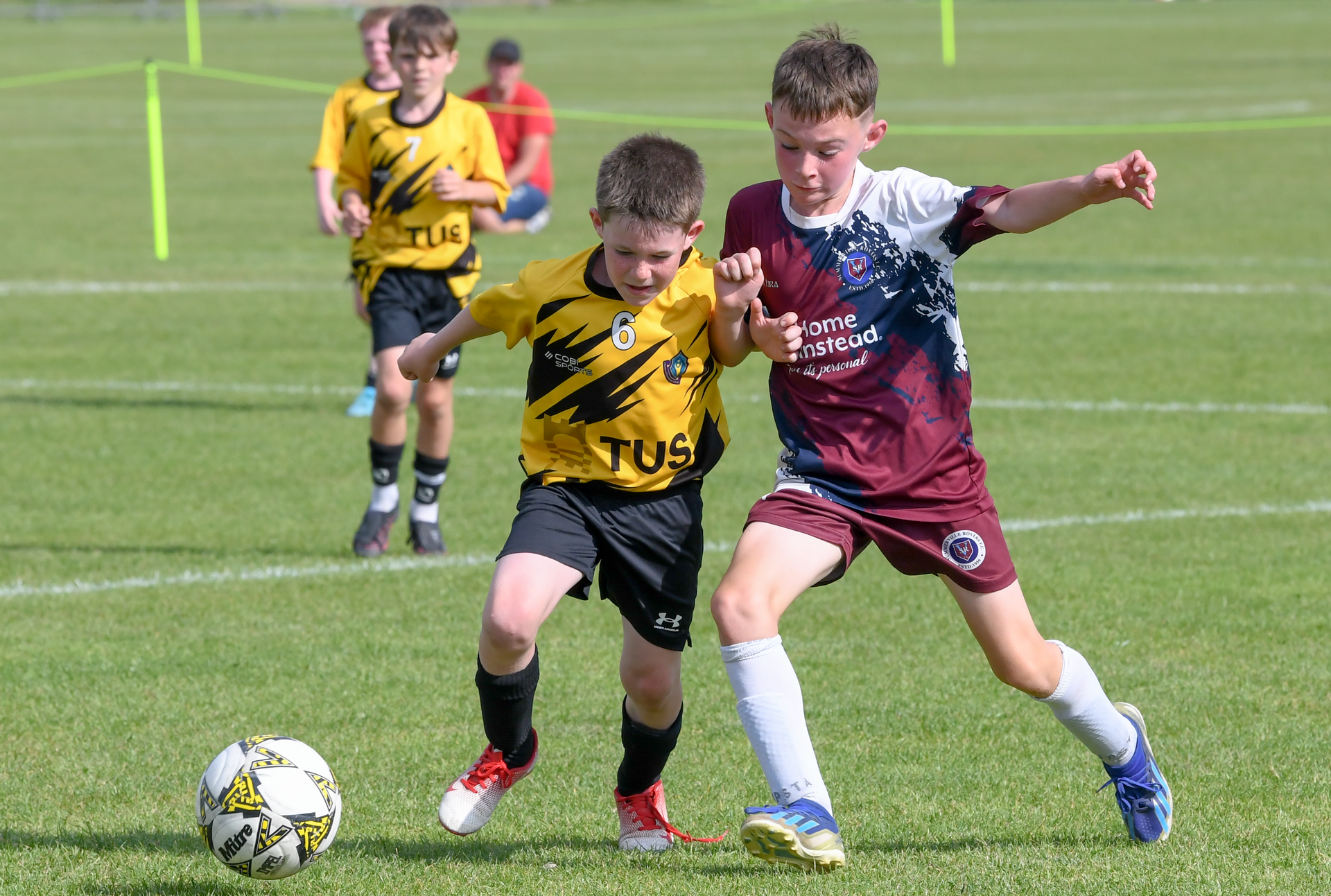 Two young boys are playing soccer on a field.
