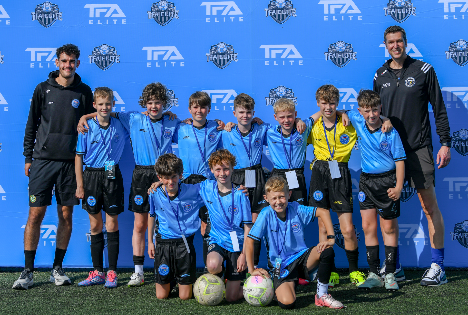 A group of young boys are posing for a picture on a soccer field.