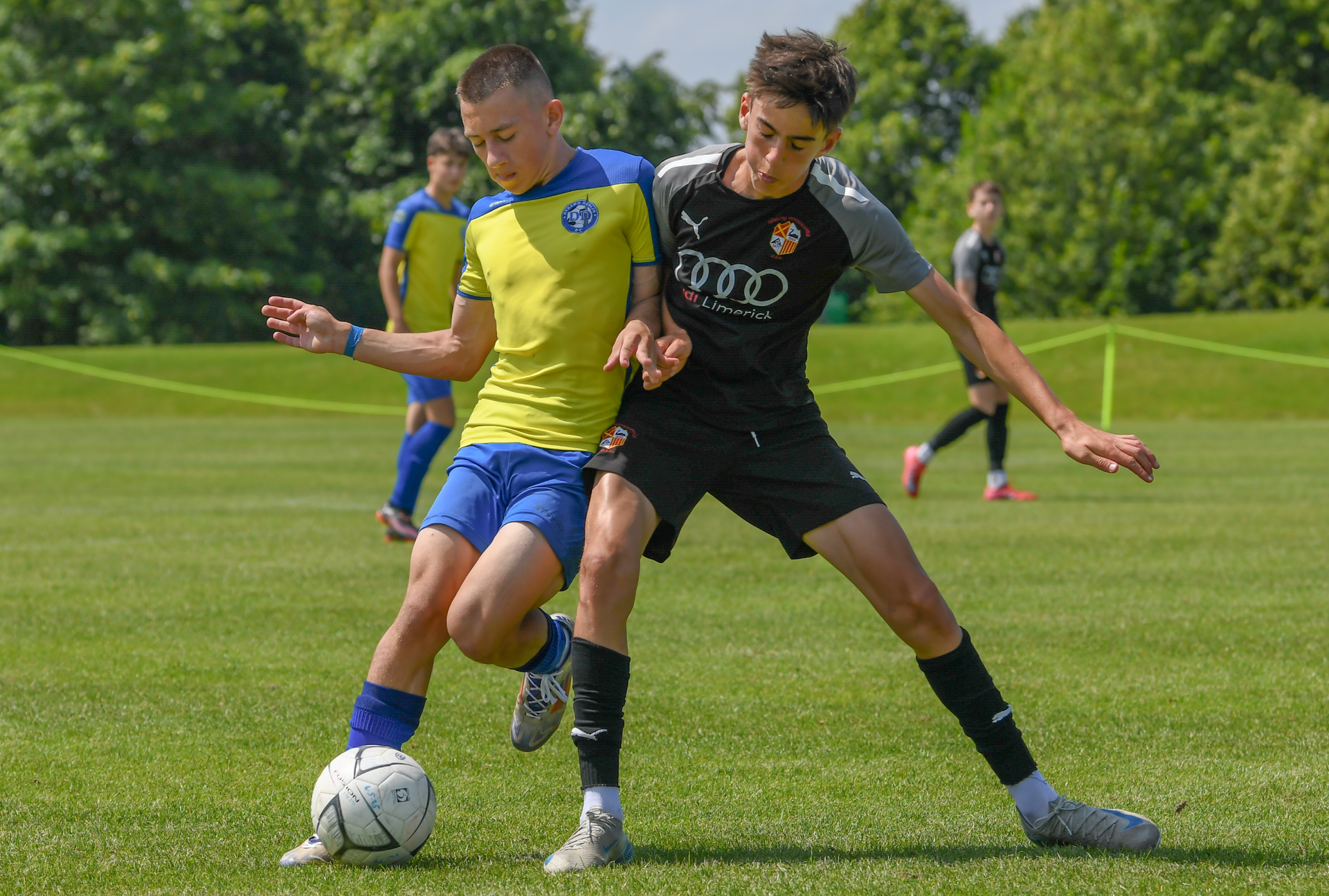 Two young men are playing soccer on a field.