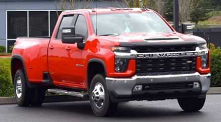 White lifted Ram pickup truck with large tires parked outside.