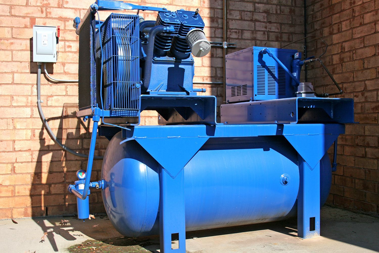 A blue compressor outside of a business building. A blue compressor outside of a business building.