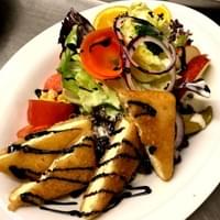 Eine Nahaufnahme eines Tellers mit Gemüse und Brot auf einem Tisch.