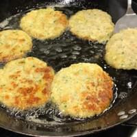 Krabbenkuchen werden in einer Bratpfanne auf einem Herd zubereitet.