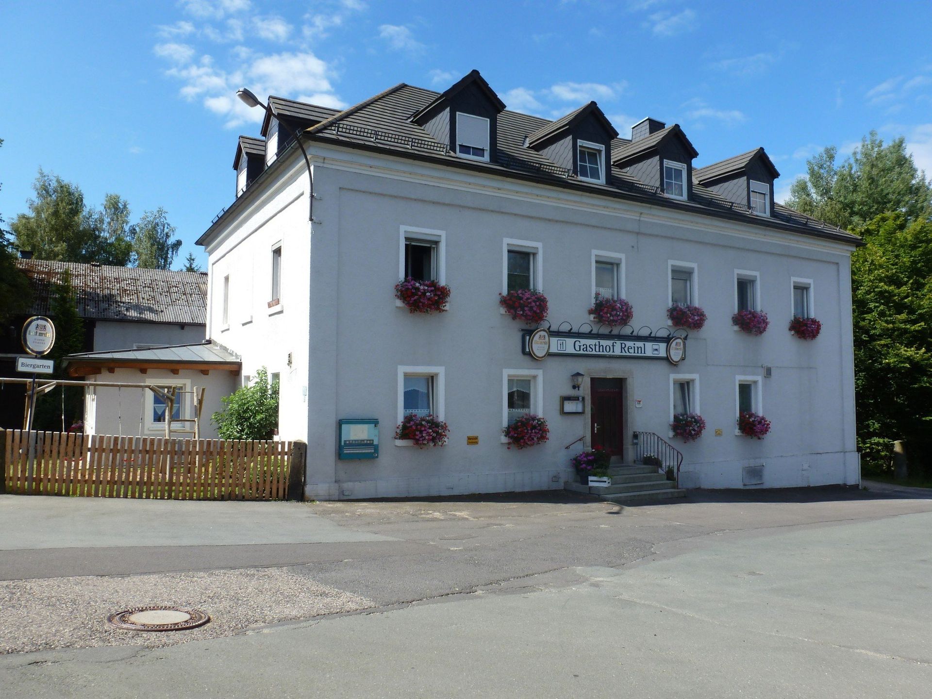 Ein großes weißes Gebäude mit Blumen an den Fenstern