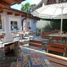 Vor einem Restaurant gibt es viele Tische und Stühle.