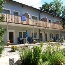 Ein großes Gebäude mit einem Balkon und Stühlen darauf.