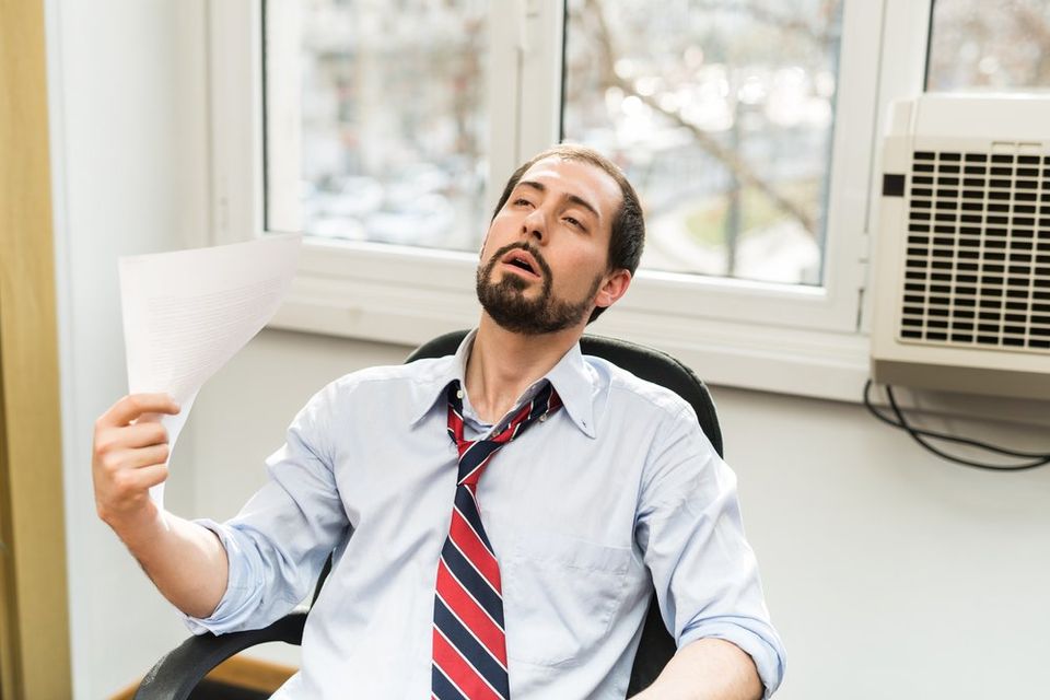 man hot in office with broken air conditioner