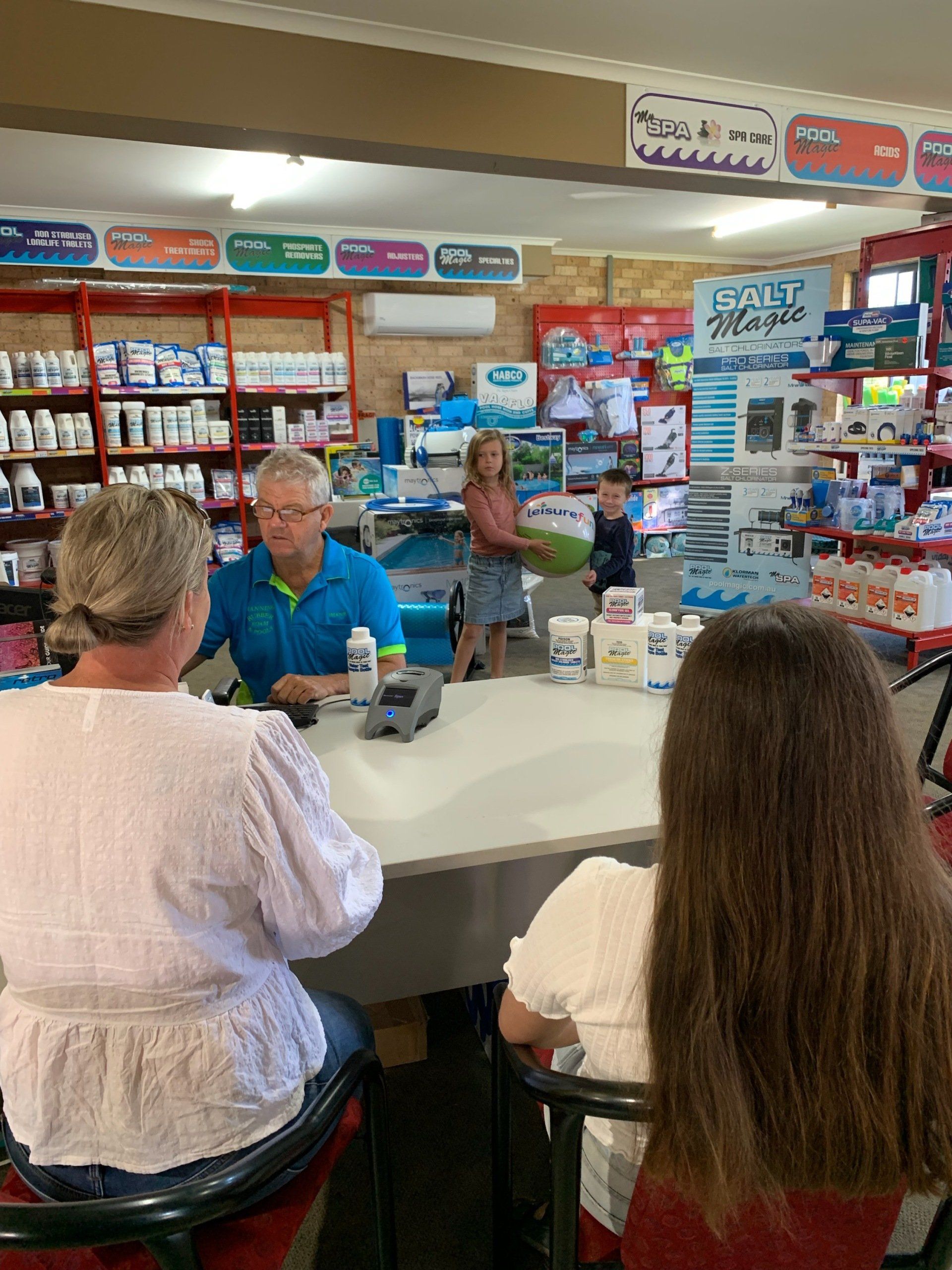 A Group Of People Are Sitting At A Table In A Store — Manning Pools, Rubber & Foam In Taree, NSW