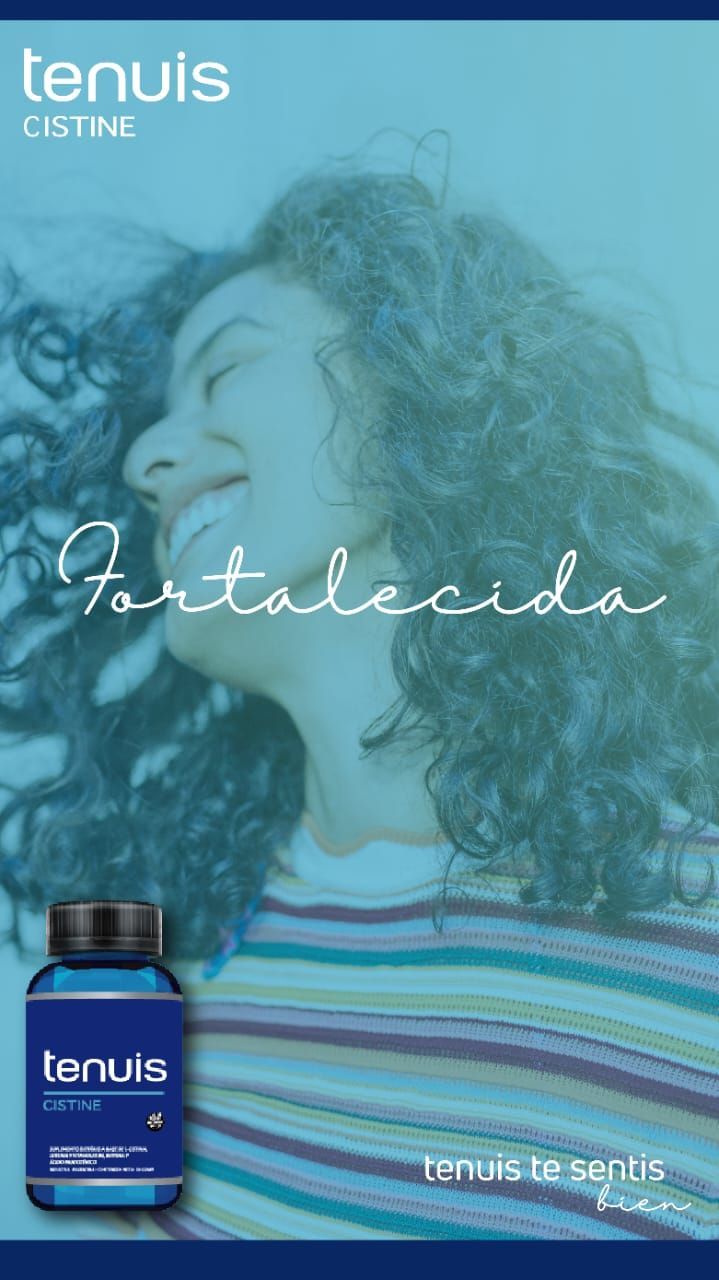 Una mujer con cabello rizado sonríe junto a una botella de un producto.