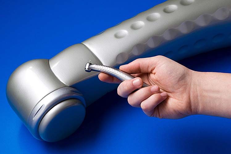 A person is holding a dental drill in their hand