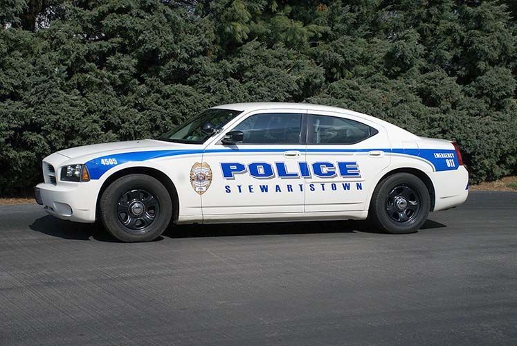A white police car is parked on the side of the road