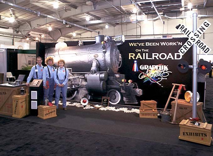 A group of people standing in front of a sign that says we 've been working on the railroad