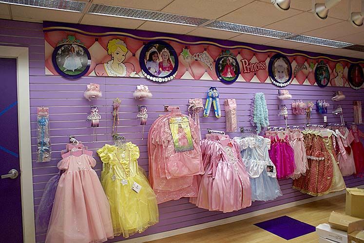 A purple wall with a bunch of dresses on it