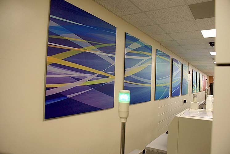 A hallway with paintings on the wall and a green light.