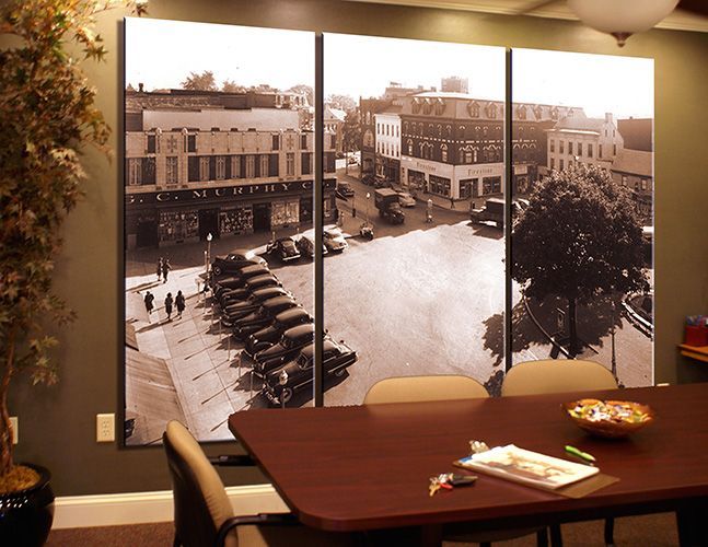 A room with a large picture on the wall above a table