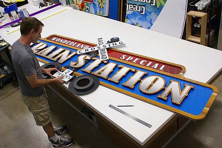 A man is working on a train station sign