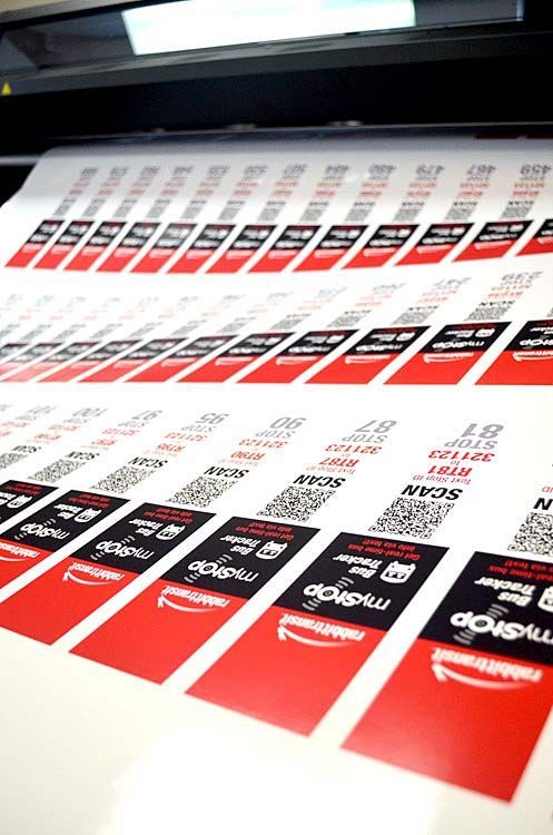 A bunch of stickers are being printed on a printer