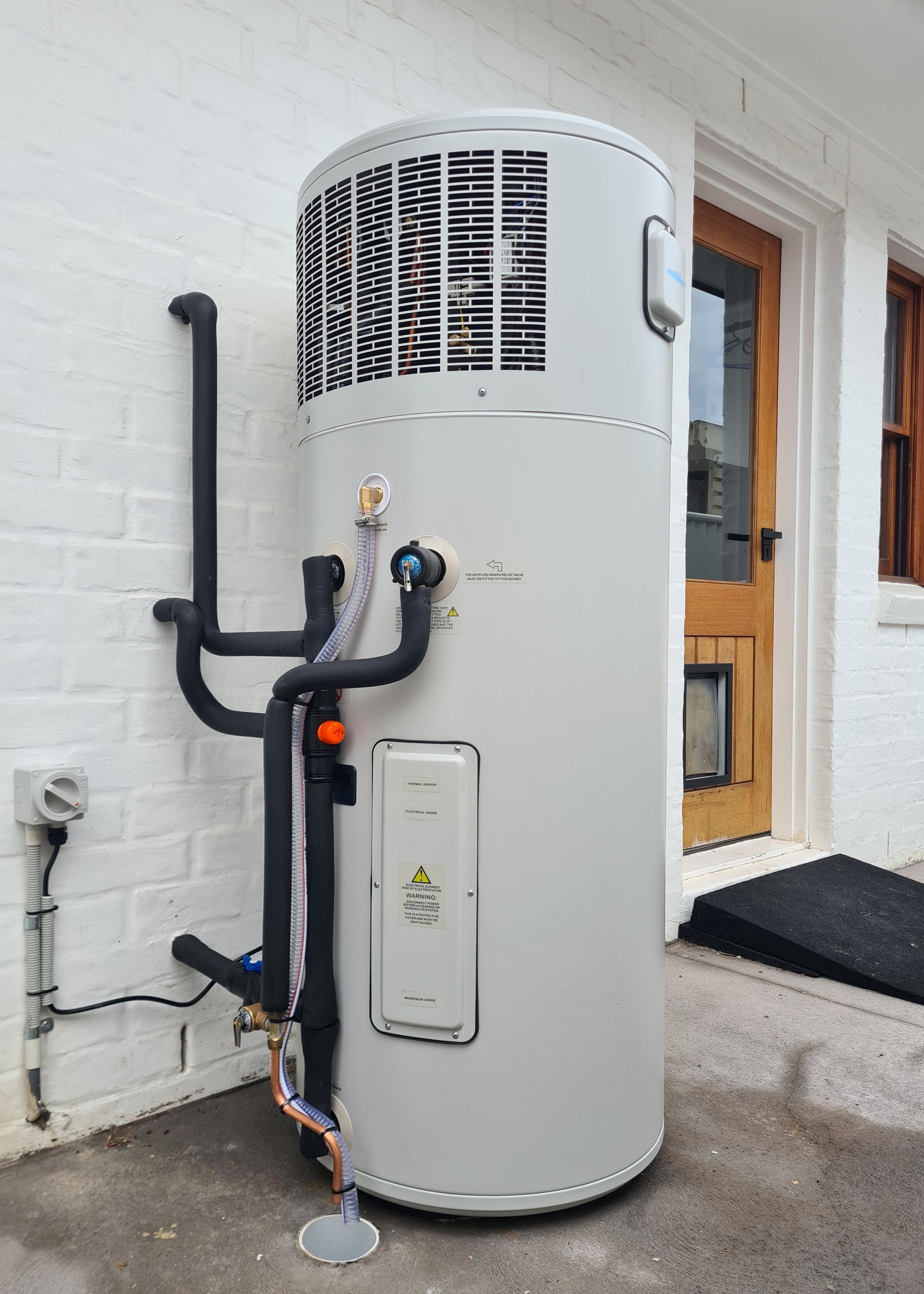 A White Refrigerator Is Sitting in A Room with A Lot of Pipes — 24/7 HOT H2O in Valdora, QLD