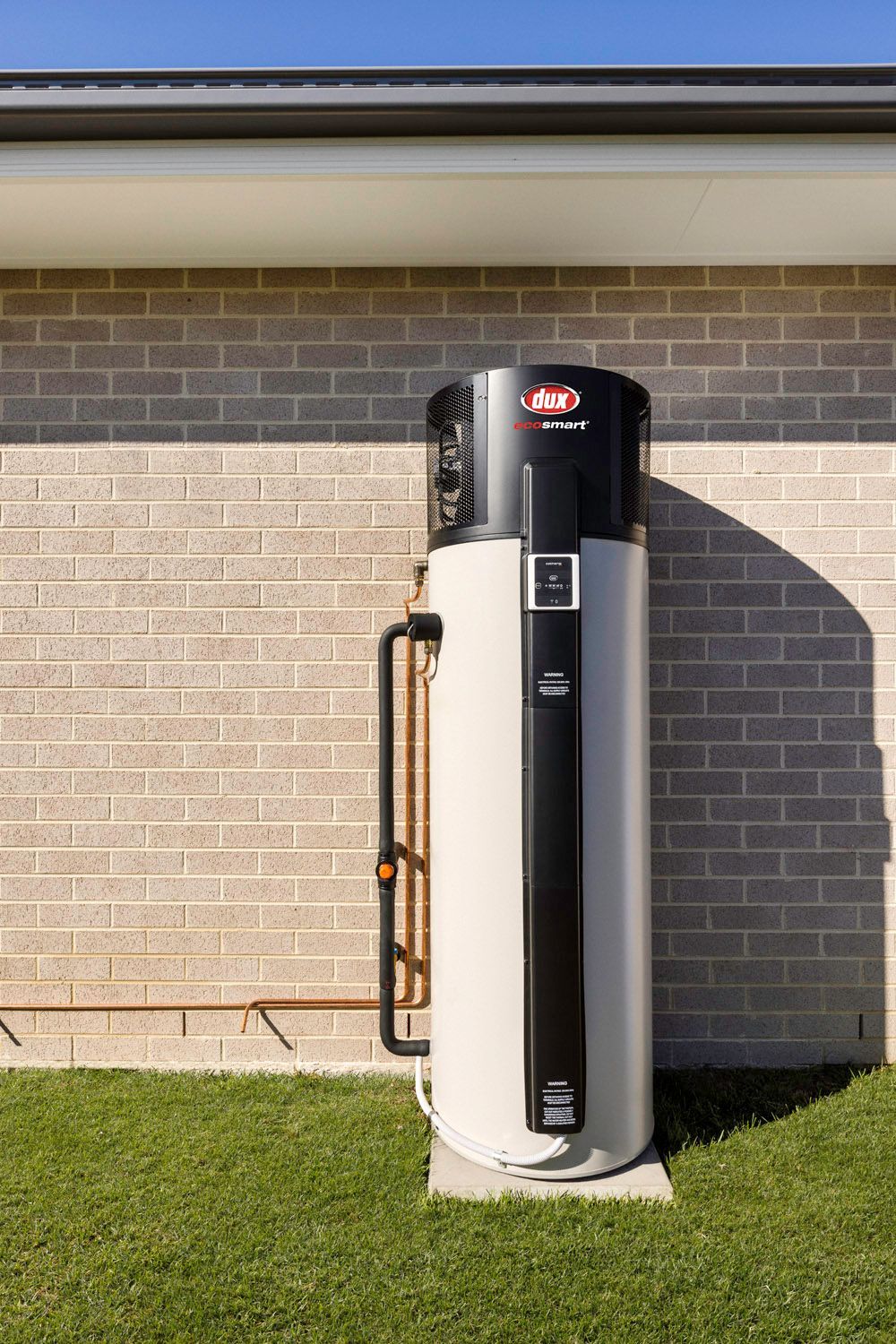 A Man in A Red Shirt Is Working on A Water Heater — 24/7 HOT H2O in Valdora, QLD