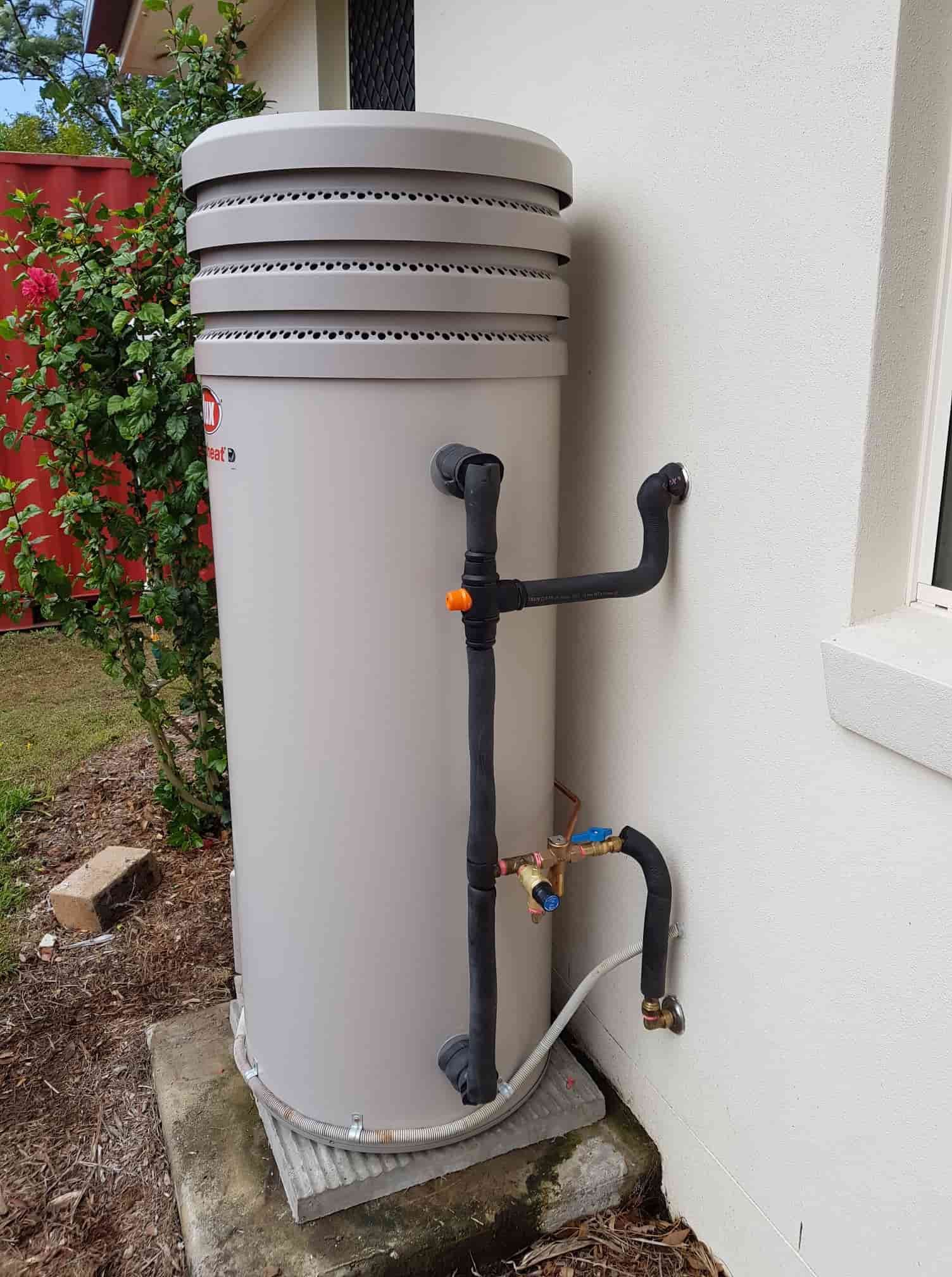 A Water Heater Is Sitting on The Side of A Building Next to A Window — 24/7 HOT H2O in Nambour, QLD